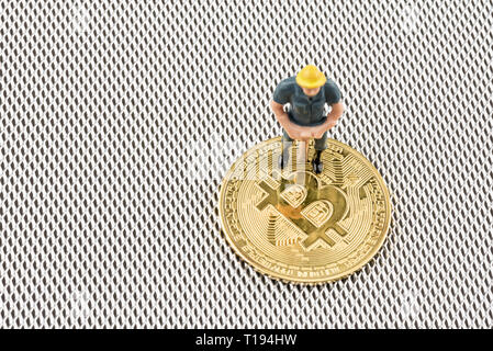 Close up vista macro di minatore figurina su bitcoins con argento metalizzato sfondo . cryptocurrency concetto. Foto Stock