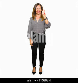 Bella Età media business donna mostra e rivolta verso l'alto con le dita in numero tre mentre sorridente fiducioso e contento. Foto Stock