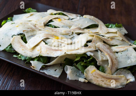 In casa carciofi freschi con insalata di rucola, rucola o rucola foglie scure sulla superficie di legno. Alimenti biologici. Foto Stock