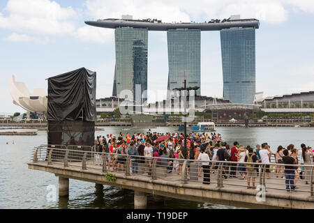 Turisti alla Marina, Singapore, con Marina Bay Sands Hotel Foto Stock