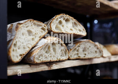 Artigiano del pane di pasta acida sul ripiano di legno in panetteria. Messa a fuoco selettiva. Foto Stock