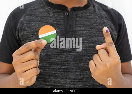 Concetto di elettorale indiana,persona in possesso di adesivo di votare per il miglior indiano in background isolato Foto Stock