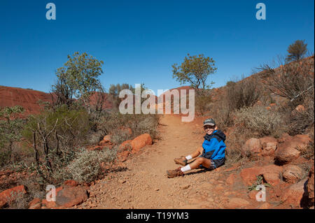 Ragazzo prende una pausa su un sentiero a piedi attraverso Kata Tjuta, Territorio del Nord, l'Australia Foto Stock