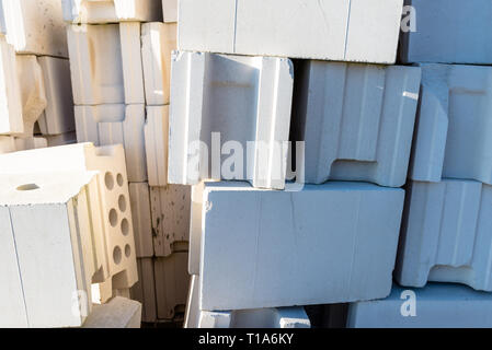 Mucchio di mattoni da calcestruzzo cellulare, bianco mattoni, mattoni forati con fori di cava all'interno. Foto Stock