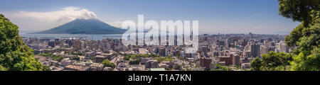 Panorama della città di Kagoshima con eruttate vulcano Sakurajima e Baia di Kagoshima in una limpida giornata estiva. Kagoshima, Kyushu, a sud del Giappone. Asia. Foto Stock