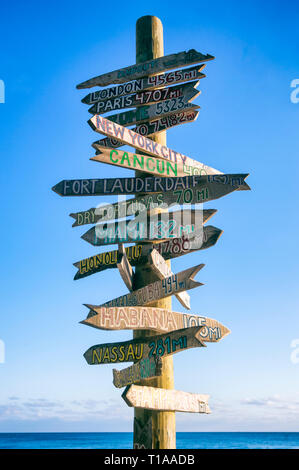 Rustico cartello in legno che indica la via verso un punto di riferimento città contro blu luminoso cielo tropicale di Key West, Florida, Stati Uniti d'America Foto Stock