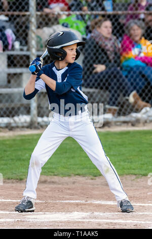 Little League pastella caricata e pronta a swing bat al passo successivo. Foto Stock