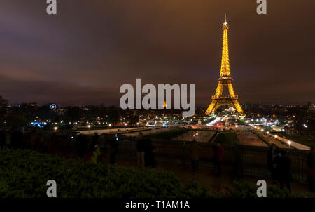 Torre Eiffel incandescente durante la notte. Orizzonte su terra. Foto Stock