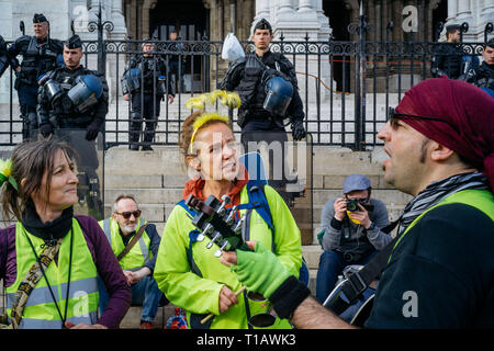 Parigi, Ile de france, Francia. 23 Mar, 2019. I manifestanti cantando prima di un gruppo di poliziotti a guardia dell'ingresso della Basilica del Sacre Coeur. Durante il XIX atto del francese Giubbotto giallo movimento, manifestanti a raccogliere le orme della Basilica Sacre Coeur, a nord di Parigi. Credito: Joao Victor Novelleto SOPA/images/ZUMA filo/Alamy Live News Foto Stock