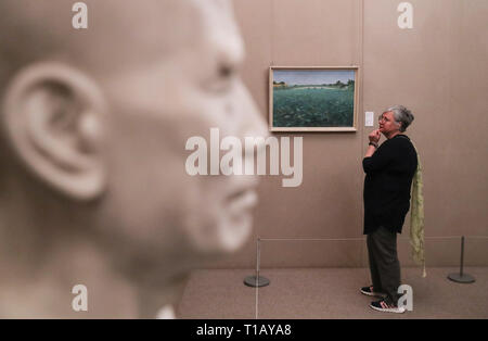 Parigi, Francia. 24 Mar, 2019. Un visitatore guarda artwork visualizzati in una mostra per ricordare il centenario del movimento Work-Study in Cina centro culturale di Parigi, Francia, 24 marzo 2019. Una cerimonia e una serie di eventi si sono tenuti qui per contrassegnare il centenario del movimento Work-Study. A partire dal 1919, migliaia di progressiva giovane cinese è andato in Francia, dove hanno lavorato nelle fabbriche di Parigi, Lione e Montargis per pagare i loro studi nel paese europeo. Credito: Xinhua/Alamy Live News Foto Stock