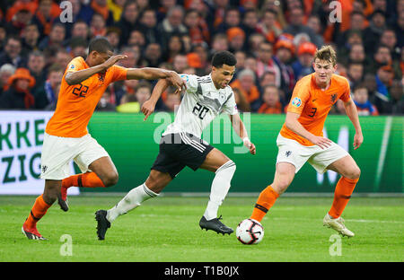 Amsterdam, Paesi Bassi. 24 Mar, 2019. Serge GNABRY, DFB 20 competere per la palla, affrontando, duello, intestazione zweikampf, azione, lotta contro Denzel DUMFRIES, NL 22 Matthijs DE LIGT, NL 3 PAESI BASSI - GERMANIA 2-3 Importante: DFB regolamenti vietano qualsiasi uso di fotografie come sequenze di immagini e/o quasi-video. La qualificazione per i Campionati Europei quali EM, 2020 stagione 2018/2019, Marzo 24, 2019 a Amsterdam, Paesi Bassi. Credito: Peter Schatz/Alamy Live News Foto Stock