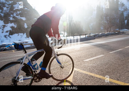 Professional bicicletta da strada racer in azione all'alba del giorno Foto Stock