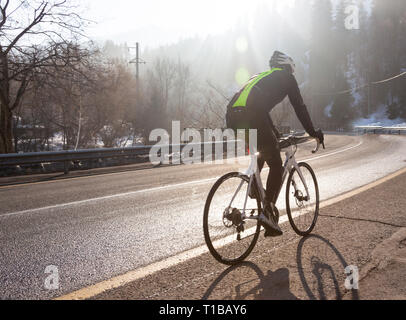 Professional bicicletta da strada racer in azione all'alba del giorno Foto Stock