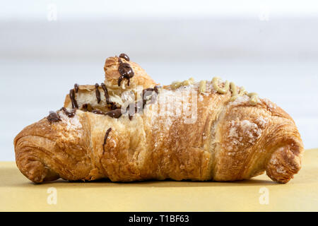 Avidi tortine farcite con cioccolato e pistacchio su un tavolo di legno Foto Stock