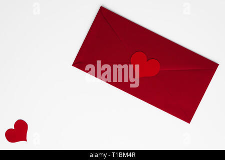 Concetto di amore lettera nella busta rossa con un romantico rosso cuori, tutti su sfondo bianco con copia spazio. Happy Valentines. Le madri o Womens giorno beau Foto Stock