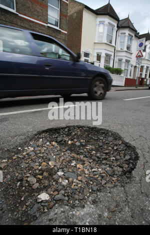 È sotto embargo per 0001 Martedì 26 Marzo una buca in una strada a Tooting, SW di Londra. L annuale delle autorità locali di manutenzione stradale sondaggio ha rilevato alcuni 1,86 milioni di buche sono state riempite durante 2018/19 confrontati con 1,53 milioni di euro nel corso dei dodici mesi precedenti l'autostrada i bilanci di manutenzione sono passati da una media di £ 20,6 milioni di £ 24,5 milioni di anno in anno. Foto Stock