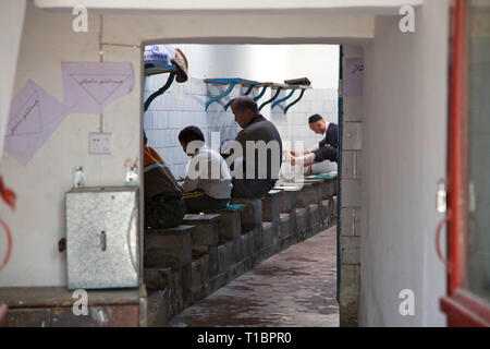 I musulmani lavare i piedi prima di pregare nella nuova moschea,, Kashgar, Xinjiang, Cina. Foto Stock