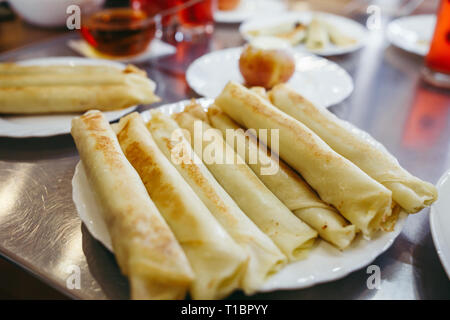Frittelle di formaggio sono serviti con miele su una piastra bianca Foto Stock