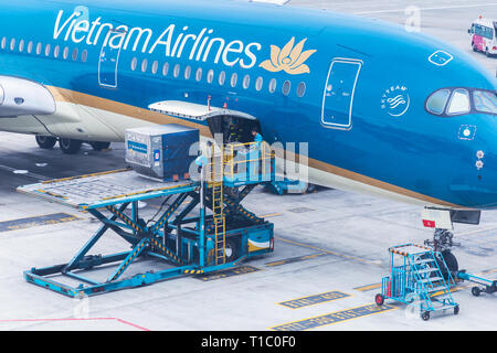 Vietnam Airlines aeromobili aria di carico ai contenitori di carico prima del volo all'aeroporto internazionale di Noi Bai ad Hanoi, Vietnam. Foto Stock