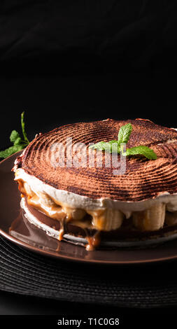 Alimentare il concetto di dessert fatti in casa torta banoffee su sfondo nero Foto Stock