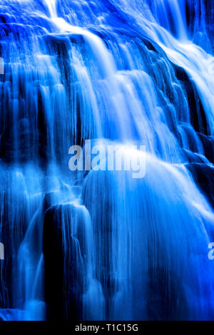 Cascata acqua rotolando pietre di fiume sottostante in una delicata sfumatura morbido flusso fluente Foto Stock