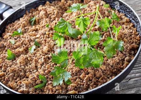 Close-up di massa del fegato con cipolla e spezie fritte in una padella, orizzontale vista da sopra Foto Stock