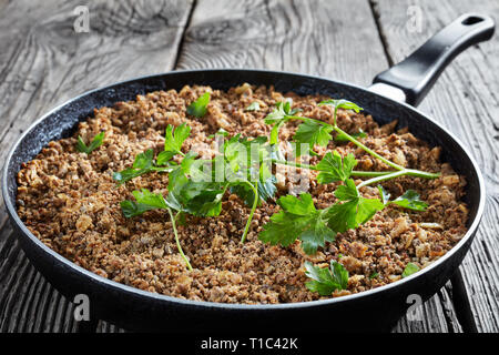 La massa del fegato con cipolla e spezie fritte in una padella, vista orizzontale dal di sopra, close-up Foto Stock