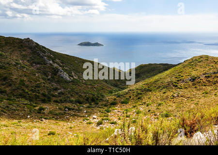 Bellissima vista dal di sopra sulla baia di greco, cielo blu, verdi colline e piccola isola nel mare blu. Colorato paesaggio estivo durante la giornata di sole in vacanza. Foto Stock