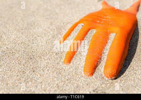 Arancione guanto di gomma lavata fino sulla costa scozzese, isola di Lewis, Ebridi Esterne, Scotland, Regno Unito Foto Stock