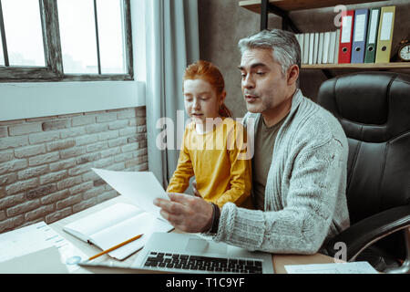 Piacevole piacevole uomo aiutando la figlia con lezioni Foto Stock