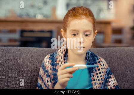 Bella ragazza emotiva di essere rimasto sorpreso con la sua temperatura Foto Stock