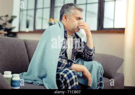 Infelice ill uomo maturo che combatte la sua malattia Foto Stock