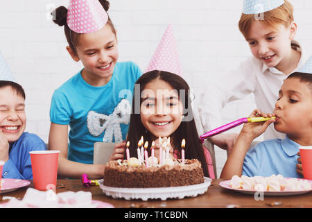 Kids guardando alla torta di compleanno con candele Foto Stock