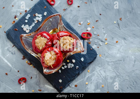 Piccanti peperoni ripieni di tonno sul cemento grigio Sfondo. Foto Stock