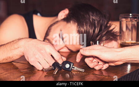 Segnalazione di incidente d'auto. Uomo alcolica con chiavi auto dormire al banco bar. L'uomo dopo aver bevuto alcool e birra nei pub. L'alcol addict con Foto Stock