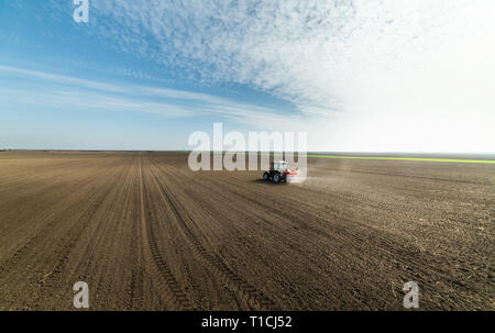 Il trattore spandimento di fertilizzanti artificiali nel campo Foto Stock