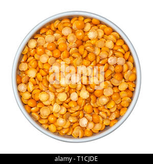 I fagioli secchi di giallo piselli spezzati Eidaho nella ciotola bianco isolato su sfondo bianco. Vista dall'alto. Foto Stock