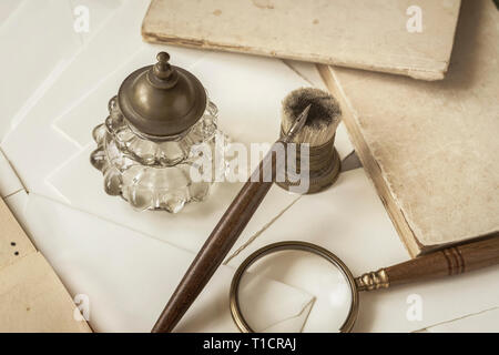 Vintage stationery, penna in legno, inkwell, Magnifier e buste, lettere da vicino. Scrivere una lettera. La memoria e la nostalgia concept Foto Stock