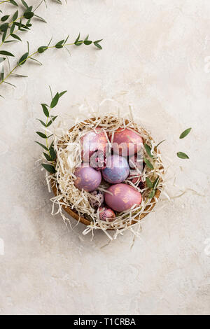 Variopinto dipinto di quaglia e uova di gallina nel nido con ramo di foglia verde. Lo sfondo per le vacanze di Pasqua. Concetto di sfondo di Pasqua. Fre Foto Stock