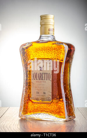 Bottiglia di liquore all'Amaretto sul gradiente dello sfondo. Amaretto proviene da Saronno in Italia. Foto Stock