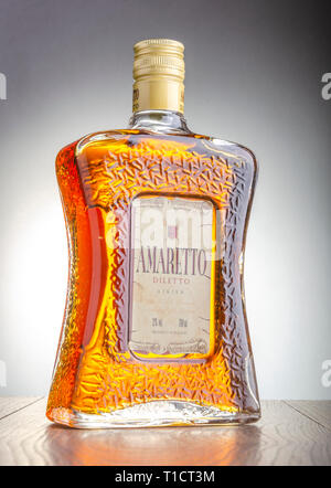 Bottiglia di liquore all'Amaretto sul gradiente dello sfondo. Amaretto proviene da Saronno in Italia. Foto Stock