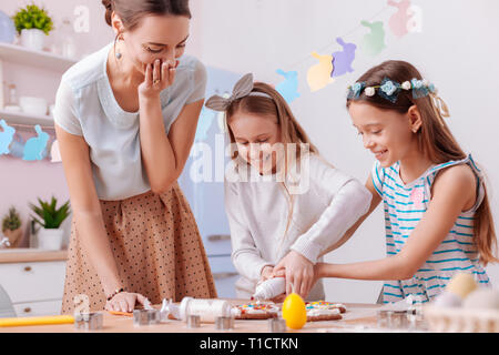 Positive le ragazze felici divertendosi in cucina Foto Stock