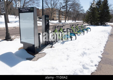 Un servizio di noleggio biciclette in aprile neve lungo il fiume Mississippi Boulevard percorso. St Paul Minnesota MN USA Foto Stock