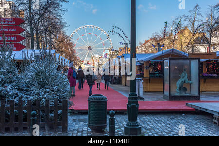 La gente che camminava lungo il mercato di Natale da stand pieno di regali e souvenir. Fiera di Natale nel centro di Bruxelles. Foto Stock