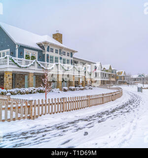 Strada innevata con impronte lungo incantevoli case. Una strada innevata con impronte lungo il bellissimo case in Alba, Utah. Scenic quartiere polmonato wi Foto Stock