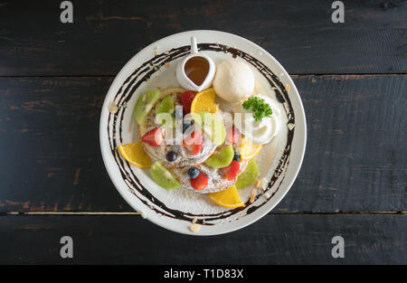 Centro Flatlay Mirtillo Fragola Kiwi Limone Waffle mantecato Gelato alla crema di cioccolato e sciroppo dolce. Fruttato dolce alimenti e bevande categoria Foto Stock