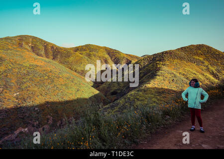 Una ragazza si erge tra i fiori selvaggi super bloom nel lago Elsinore, California primavera 2019 Foto Stock