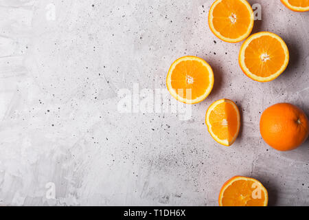 Fette di arance su sfondo grigio, vista dall'alto. Questo frutto è una fonte di vitamine e di materie prime per la produzione di succhi di frutta Foto Stock