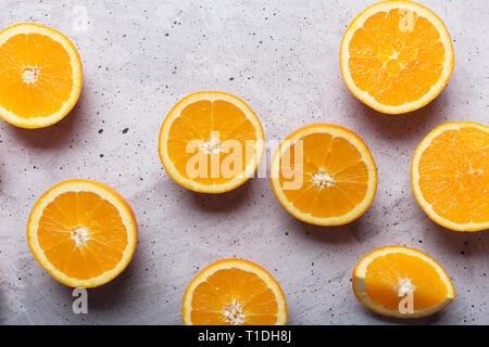 Fette di arance su sfondo grigio, vista dall'alto. Questo frutto è una fonte di vitamine e di materie prime per la produzione di succhi di frutta Foto Stock