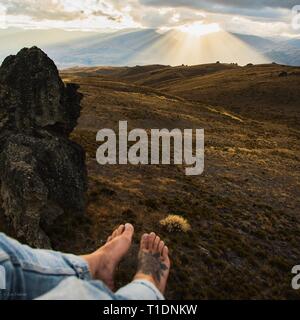 Guardare il tramonto dall alto di un masso in da qualche parte in Cromwell, NZ Foto Stock